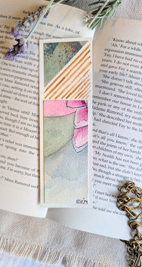 Watercolour bookmark with orange diagonal stripes and detailed black linework of a flower, handmade on eco-friendly paper.