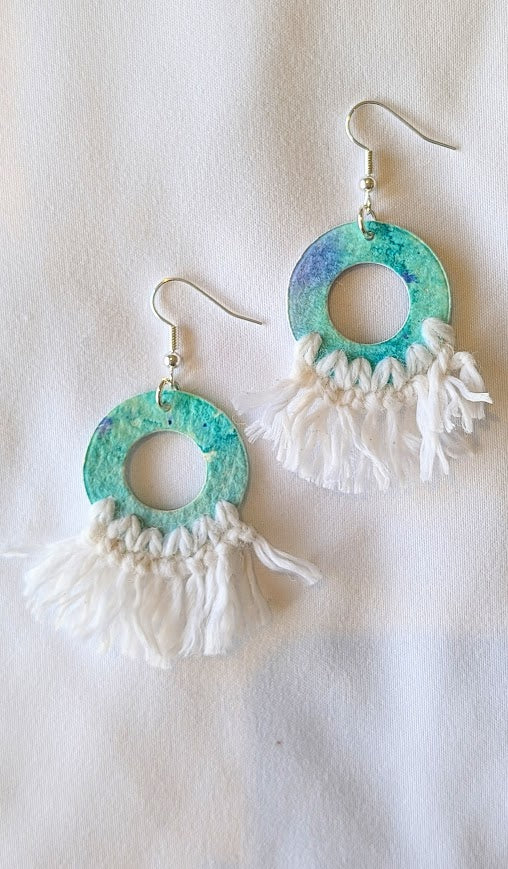 Turquoise and white fringe earrings on a light background