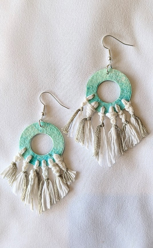 Turquoise earrings with tassels on a light background