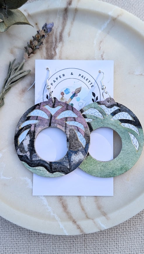 Lightweight circle earrings made from painted watercolour paper with botanical cut outs and upcycled silver vinyl backing. Sustainable and eye-catching design.