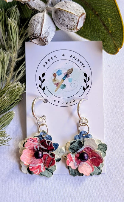 Floral earrings on a 'Paper & Palette Studio' branded card with greenery in the background.