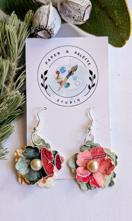 Floral earrings with pearl beads on a Paper & Palette Studio card and leaves in the background.